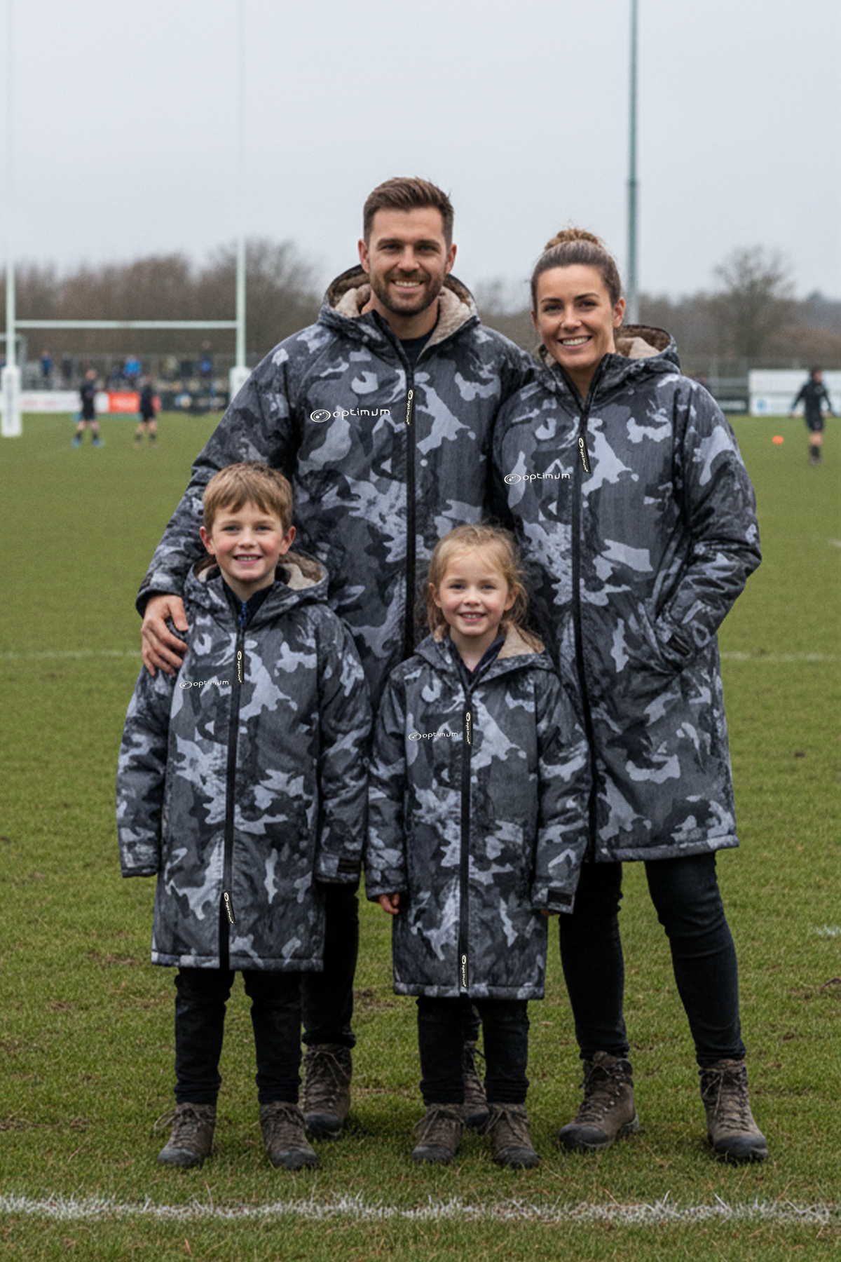 Family of four wearing grey camo Optimum changing robes on a rugby pitch - Optimum