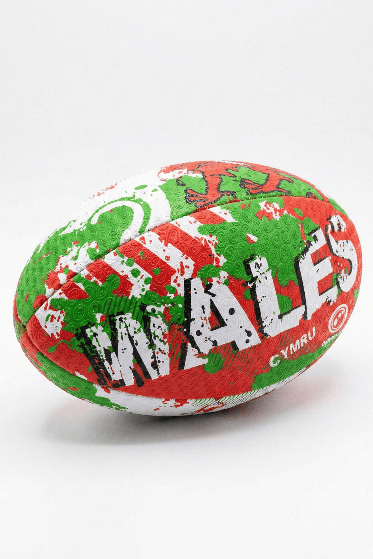 Green, red and white Optimum Wales rugby ball with WALES CYMRU print, resting on its side on white - Optimum