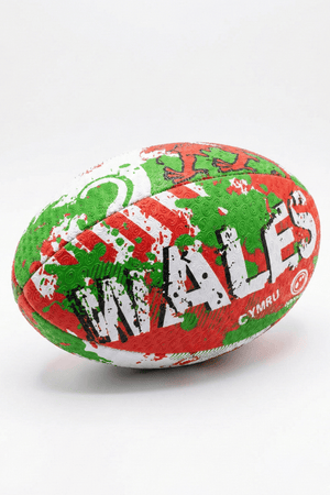 Green, red and white Optimum Wales rugby ball with WALES CYMRU print, resting on its side on white - Optimum