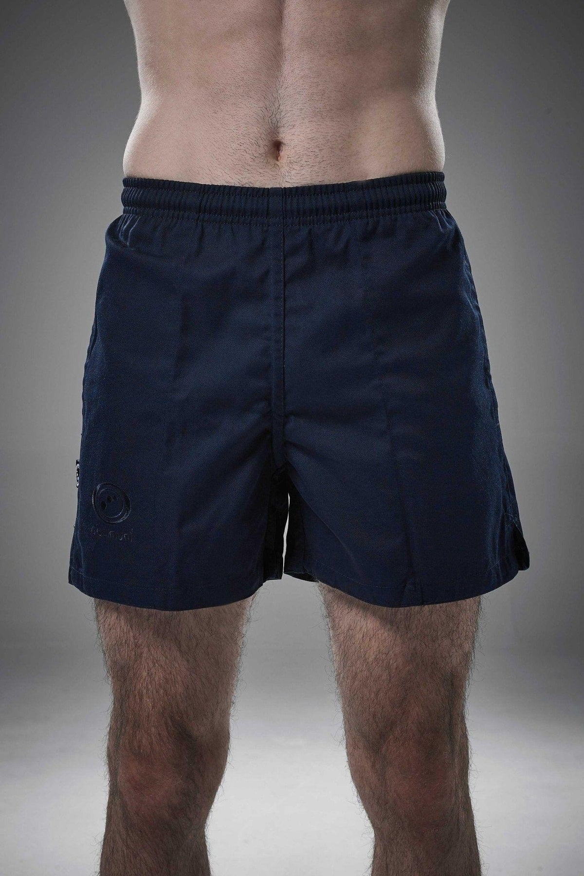 Man wearing navy Optimum Auckland rugby shorts front-on with tonal logo on leg, grey background - Optimum