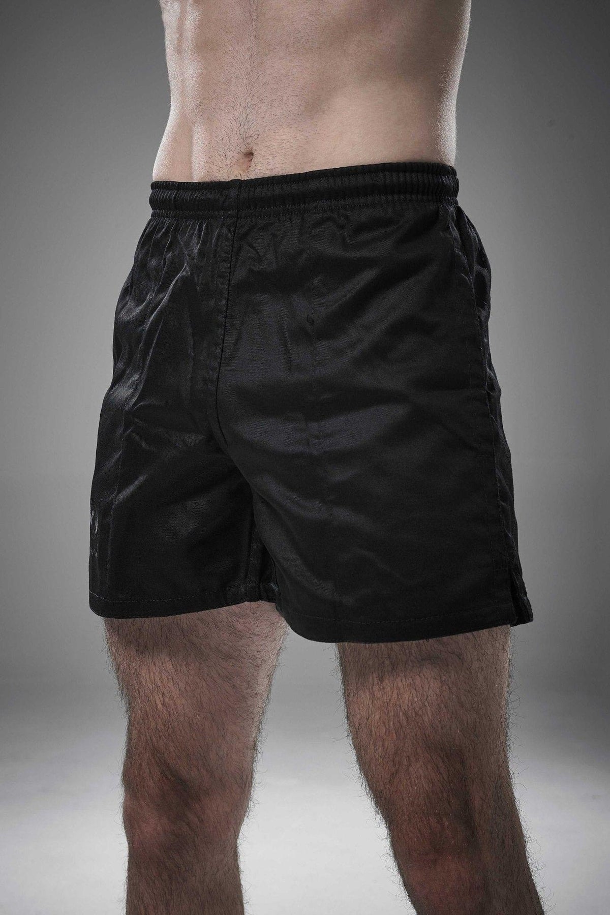 Man wearing black Optimum Auckland rugby shorts, front view on grey studio background - Optimum