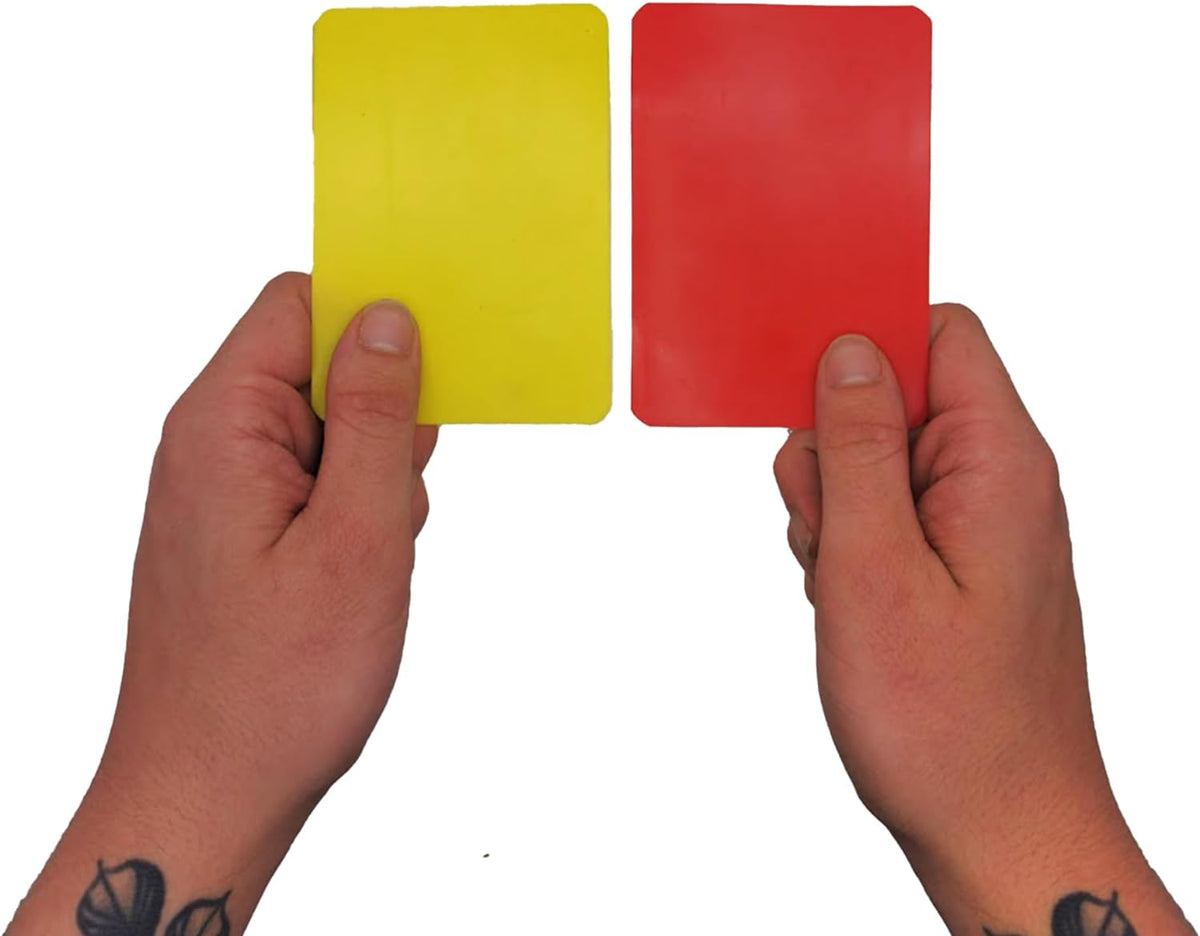 Hands holding up yellow and red referee cards against white background - Optimum