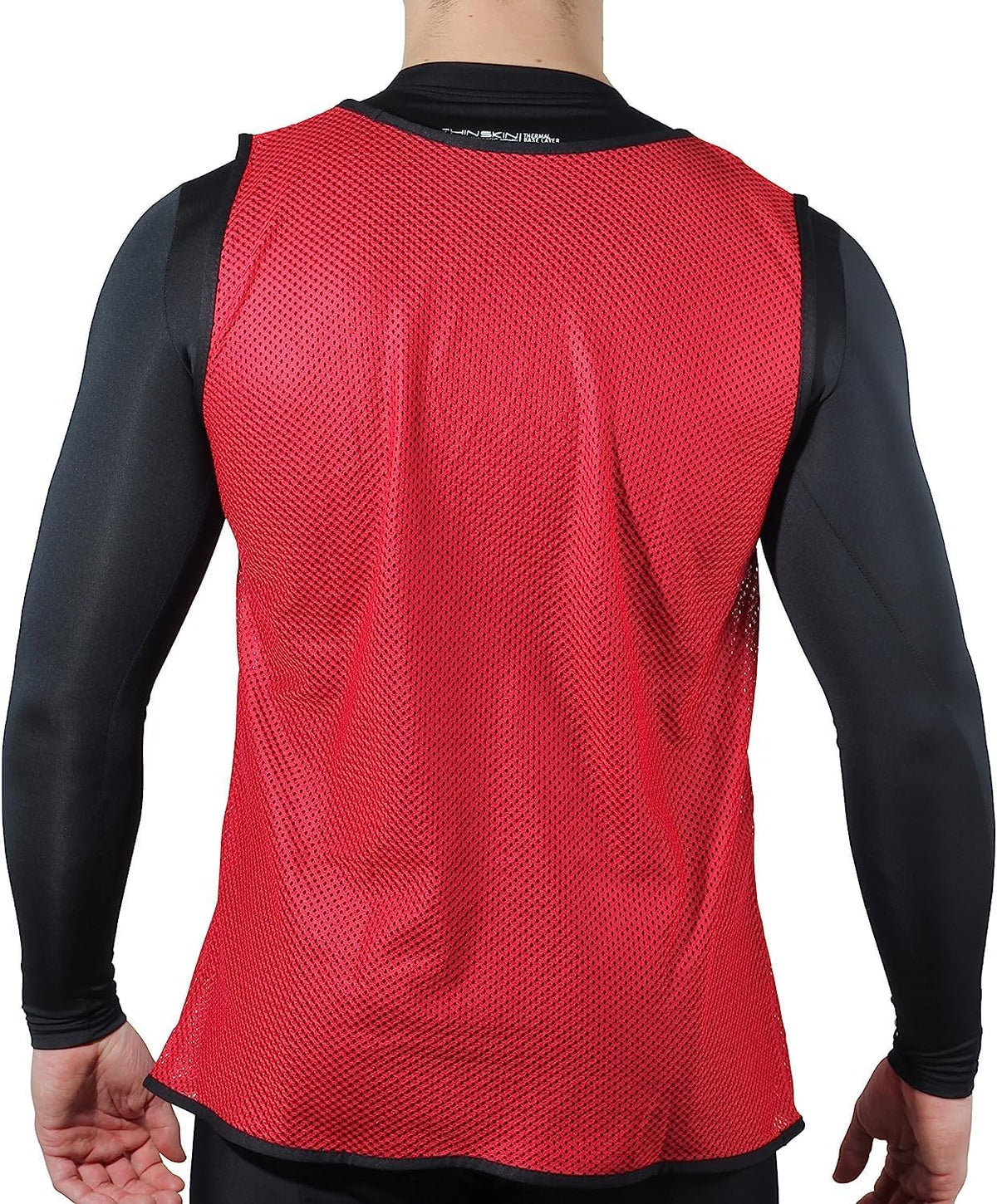 Red mesh Optimum training bib worn over black top by model, rear view on white background - Optimum